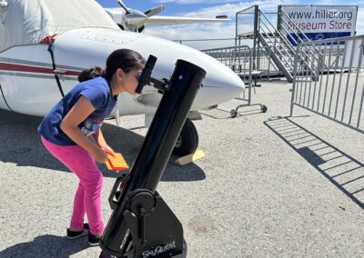 Child looking at Solar Eclipse through telescope at the Hiller Aviation Museum.